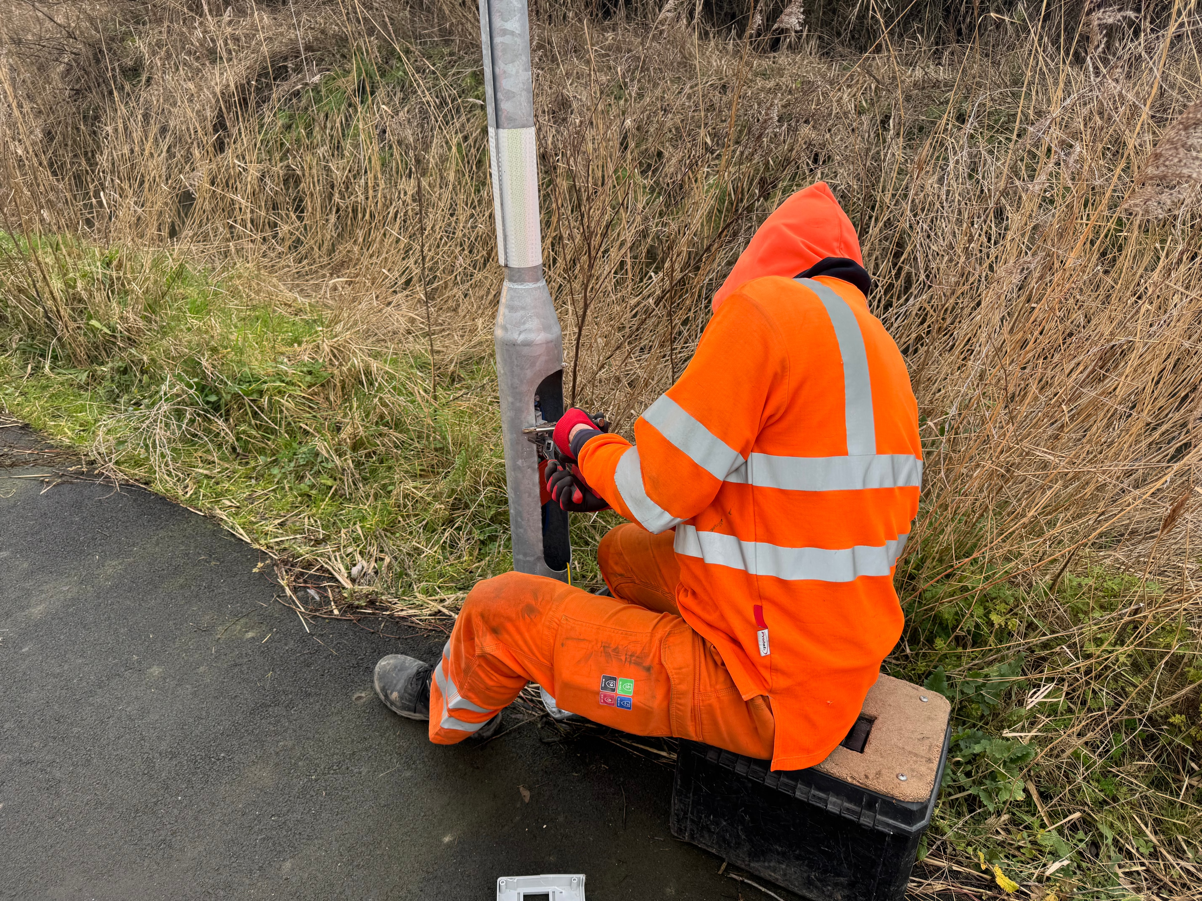 ManoWorks worker in orange safety gear inspecting pipe